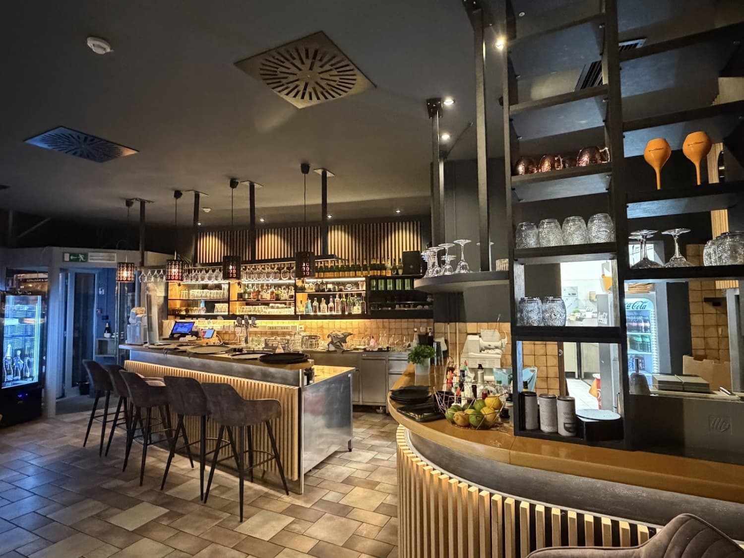 Hotelski bar z lesenim pultom in stekleninami